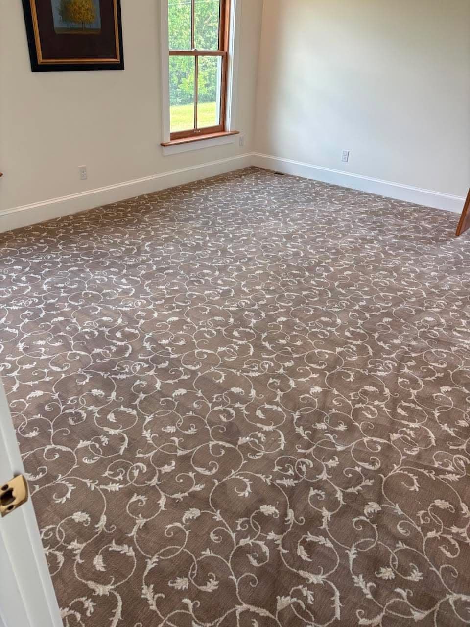 Patterned carpet installation in a formal room with wood-trimmed windows