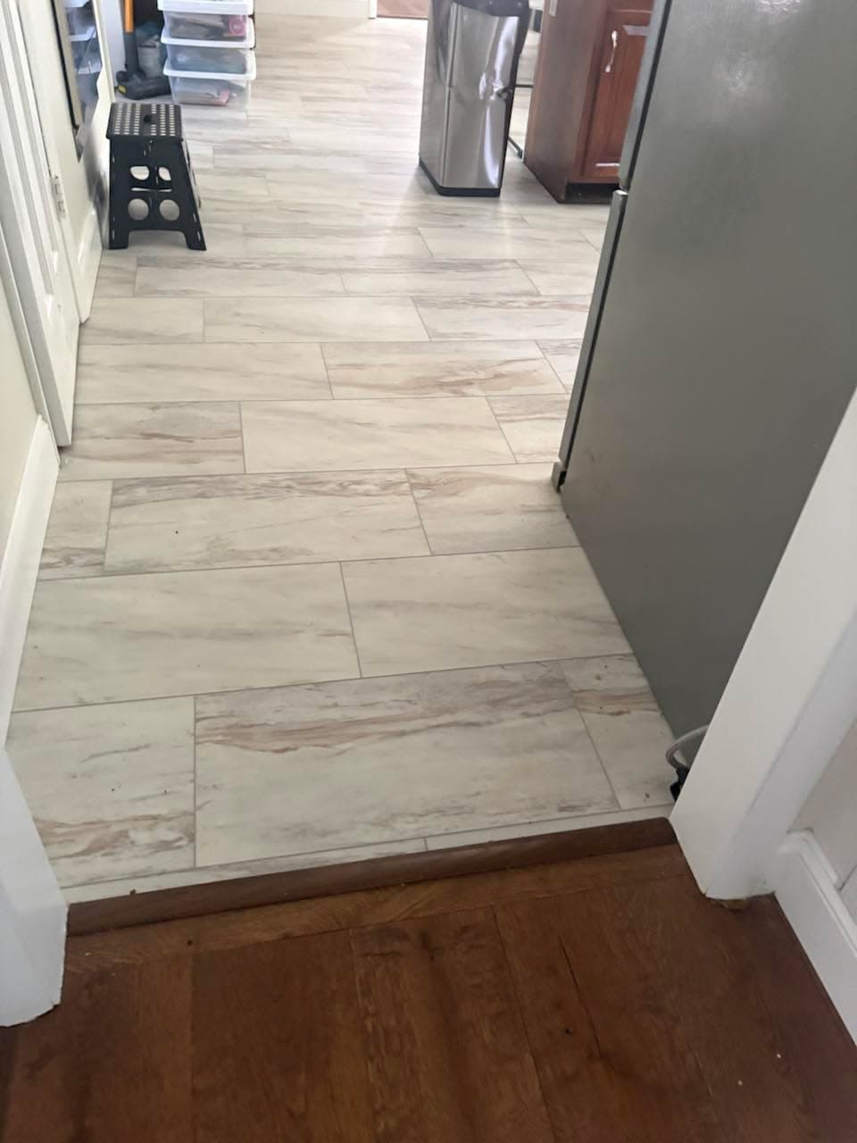 Light wood-look resilient flooring installed through a kitchen walkway